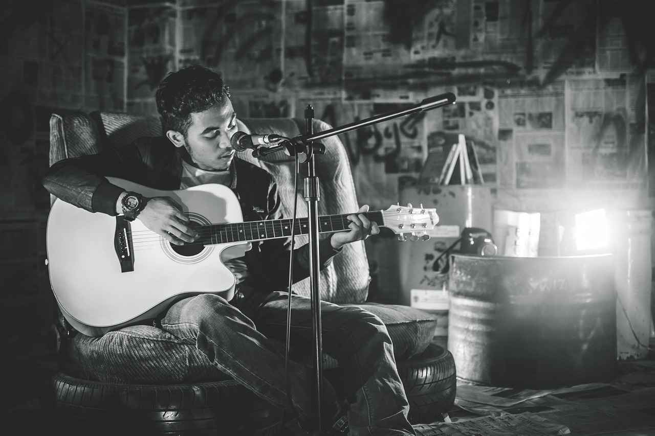 a man singing holding a guitar