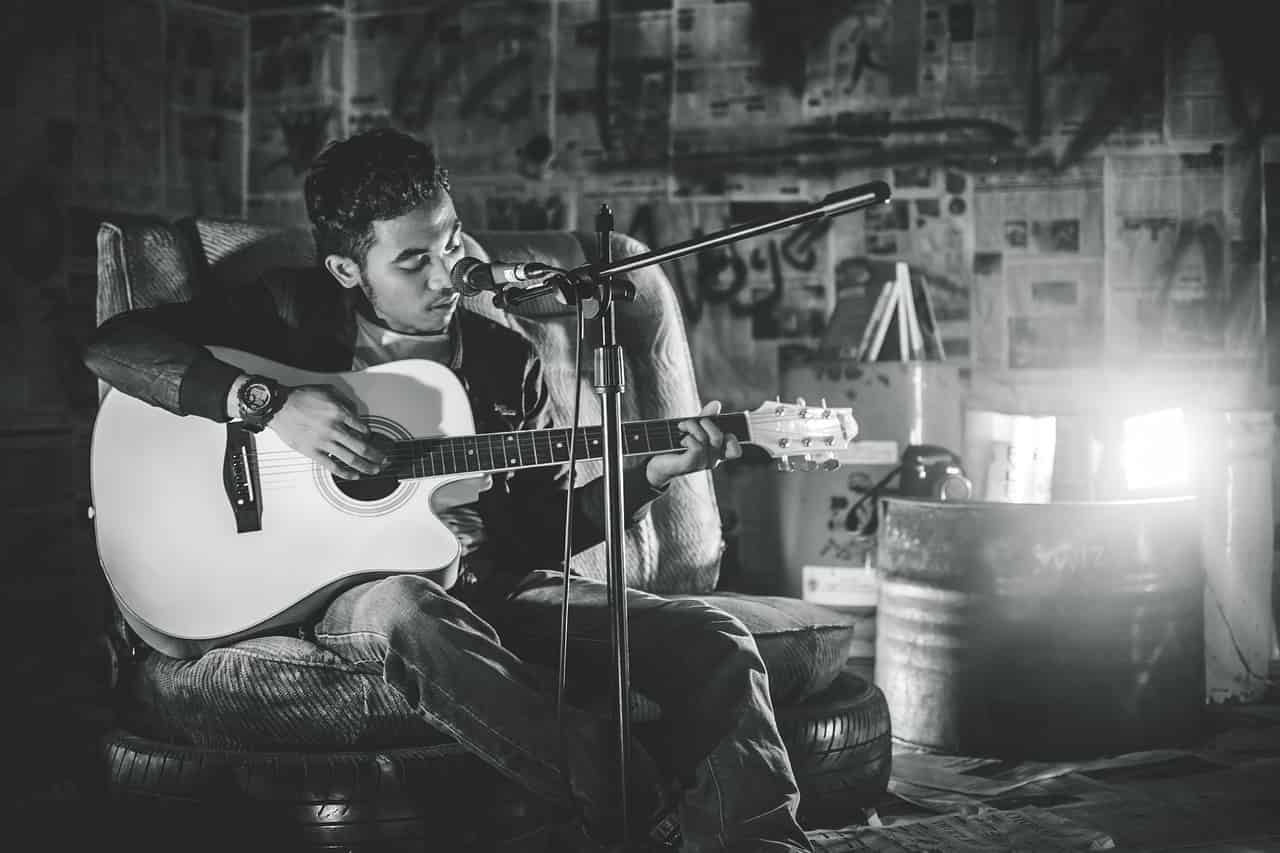 a man singing holding a guitar